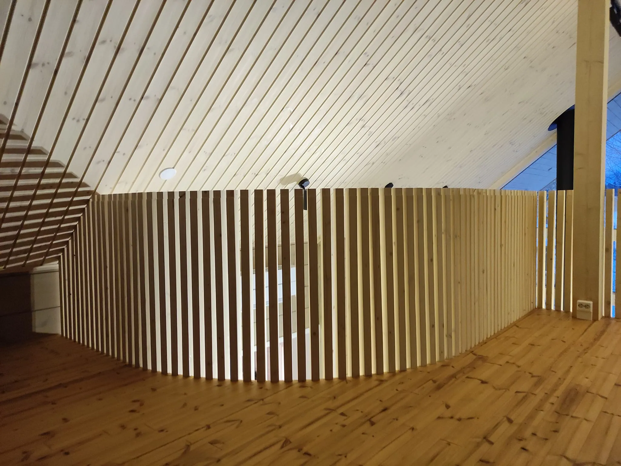 Puinen sisustus, jossa on kaareva aita, puulattia ja katto.